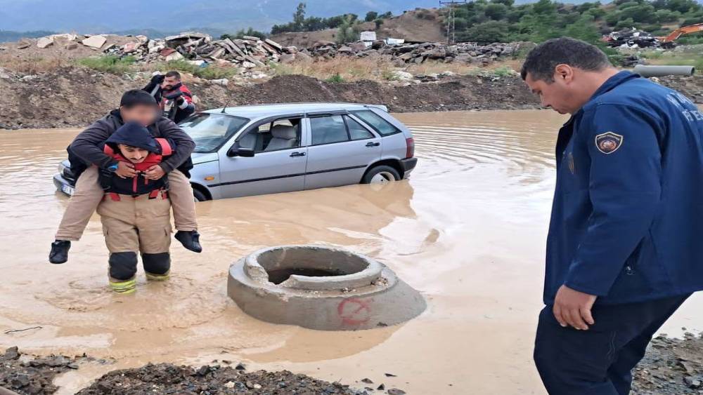 İtfaiyeci, g&ouml;le d&ouml;nen yolda mahsur kalan &ccedil;ocuğu sırtında taşıyarak kurtardı

